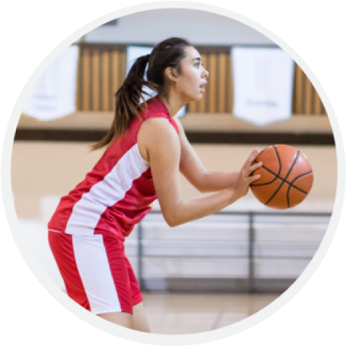 A girl in red and white playing basketball.