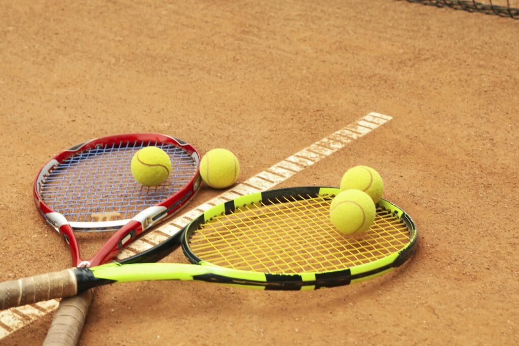 Tennis racquets with tennis balls on clay court